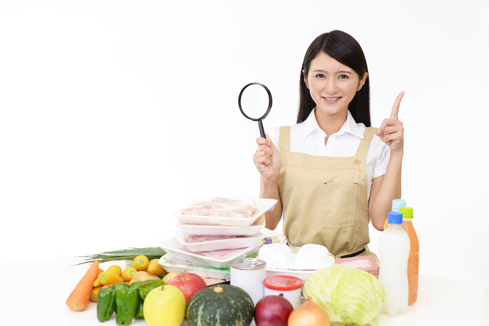 沢山の食品と指をさす女性