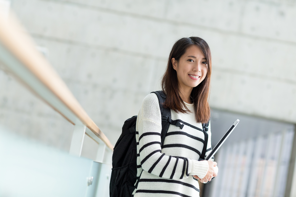 大学のキャンパスで笑顔で振り返る理系女子