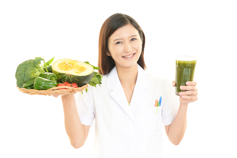 野菜と青汁を持つ食品保健指導士