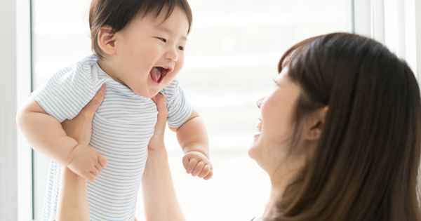 高い高いして赤ちゃんをあやす女性